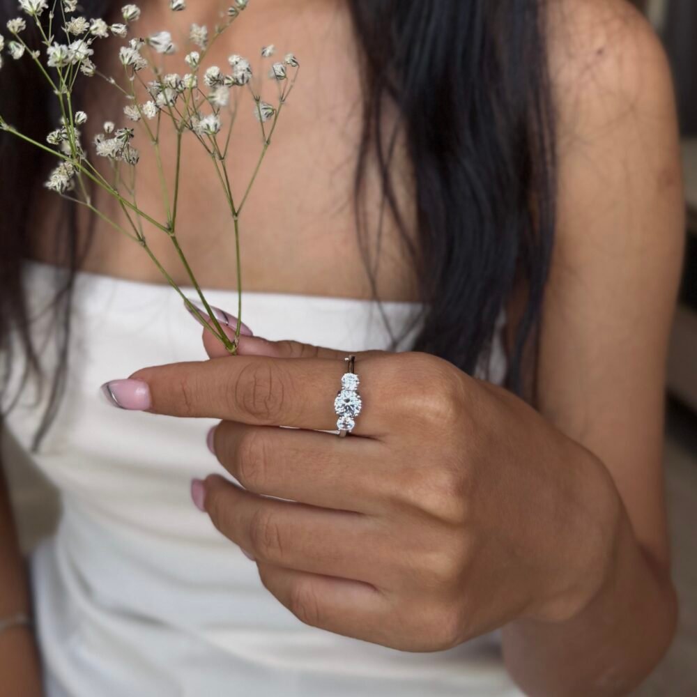 Silver ring with a delicate floral cluster of sparkling stones on a sleek polished band.